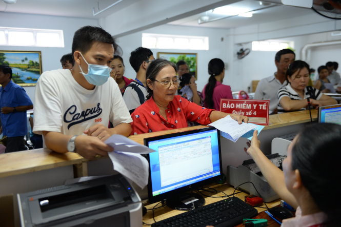 Người dân tham gia BHYT để giảm chi phí khi khám chữa bệnh. Trong ảnh: bệnh nhân BHYT đóng tiền khám bệnh tại Bệnh viện Q.Thủ Đức (TP.HCM) - Ảnh: Hữu Khoa