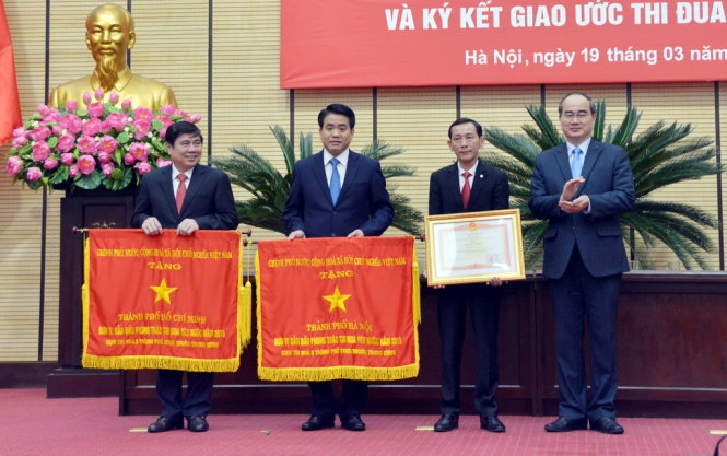 Ông Nguyễn Thiện Nhân trao cờ thi đua và bằng khen cho TP Hà Nội và TP.HCM trong sáng 19-3 - Ảnh: Xuân Thành