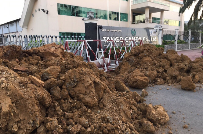 Người của KCN Tân Đức dựng rào chắn, đào ống cắt nguồn nước vào doanh nghiệp vào chiều 17-3 và sau đó tiếp tục đổ đất chắn lối đi - Ảnh: CTV
