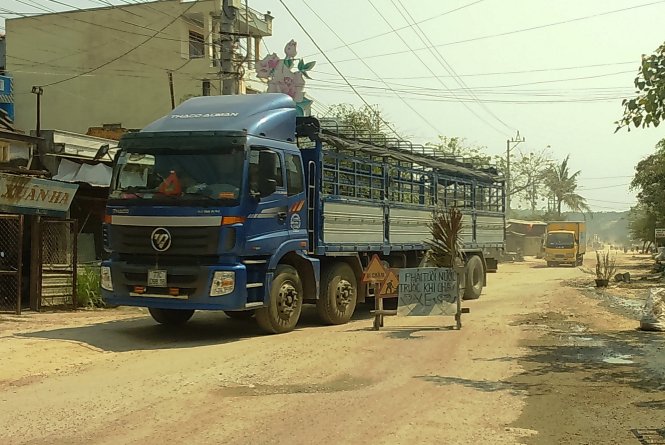 Người dân dựng hàng rào chặn xe tải chở đất đá sáng 23-3 - Ảnh: X.VINH