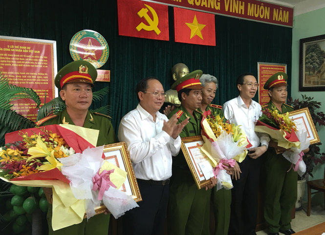 Ủy viên trung ương Đảng, Phó Bí thư Thường trực Thành ủy Tất Thành Cang và Phó Chủ tịch Ủy ban nhân dân TP Lê Thanh Liêm trao bằng khen, thưởng nóng cho Đội hình sự Q.2, Bình Tân và Gò Vấp - Ảnh: Đức Thanh