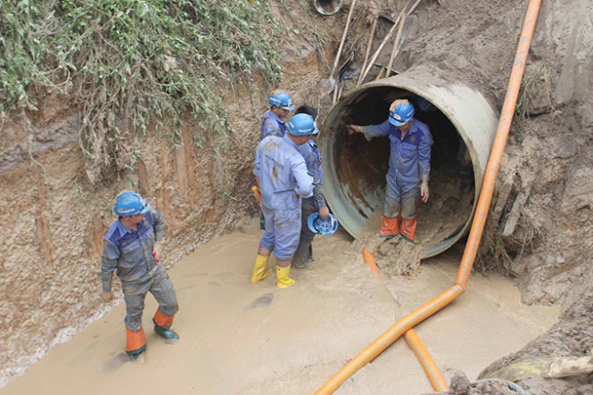 Công nhân khắc phục đoạn ống nước sông Đà bị vỡ lần thứ 13 - Ảnh: Tuấn Anh