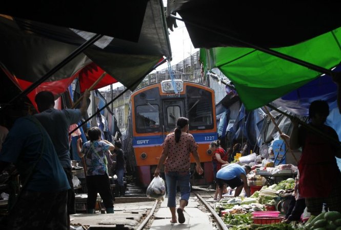 Tàu lửa chạy trong một khu chợ chật chội ở Thái Lan. Ảnh: Reuters