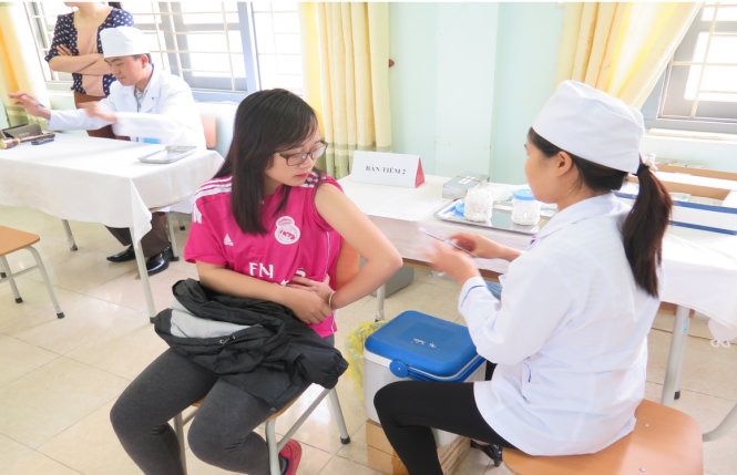 Một học sinh nữ lớp 11 đang được tiêm văcxin sởi - rubella - Ảnh: Văn Khang