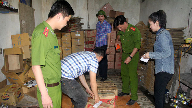 Lực lượng chức năng kiểm tra và niêm phong số hàng là dấm ăn tại cơ sở của bà Kim - Ảnh: P.Bằng