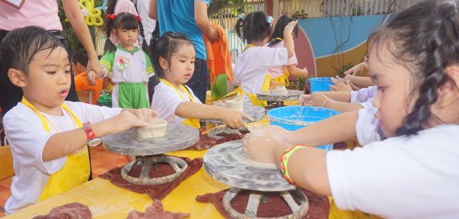 Học sinh 5 tuổi đóng vai thợ làm gốm tại ngày hội. Ở trò chơi này, bé được rèn kỹ năng kiên trì, khéo léo… - Ảnh: H.HG.