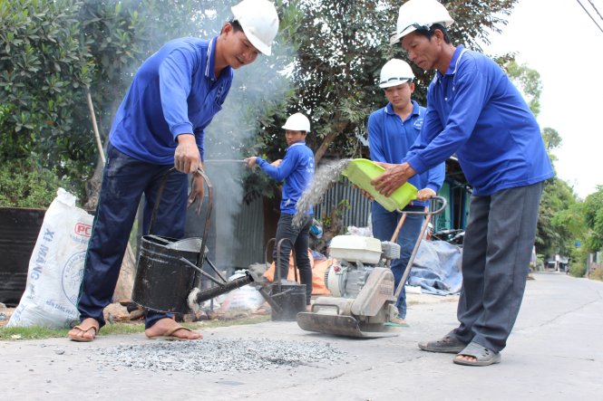 Đội vá đường tình nguyện của Trung nay được đầu tư thêm máy móc từ tiền ủng hộ của người dân để vá thêm nhiều con đường  - Ảnh: Tiến Trình