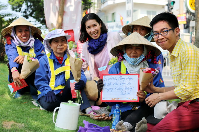 Nguyễn Hồng Việt tặng hoa cho bốn chị lao công trên đường 
Hoàng Sa (TP.HCM) chiều 30-4 - Ảnh: Ngọc Hiển