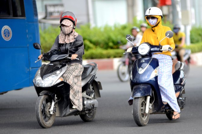 Phụ nữ Sài Gòn đối phó với nắng nóng - Ảnh: Duyên Phan