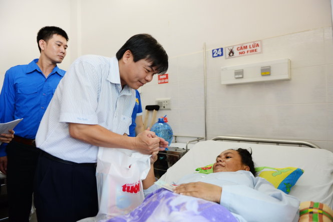 Ông Tăng Hữu Phong - tổng biên tập báo Tuổi Trẻ - thăm hỏi sức khỏe và tặng quà cho bệnh nhân điều trị tại Bệnh viện Thống Nhất trong hoạt động “Trái tim hồng tình nguyện vì sức khỏe cộng đồng” - Ảnh: Hữu Khoa