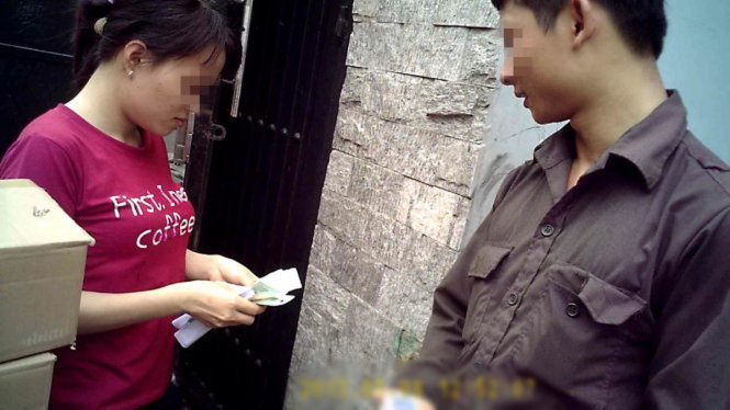 Trần Đình Tài thu tiền bán bình chữa cháy tại một xưởng may gia công trên đường Đồng Đen (P.10, Q.Tân Bình) sáng 12-5 - Ảnh: Hoàng Lộc