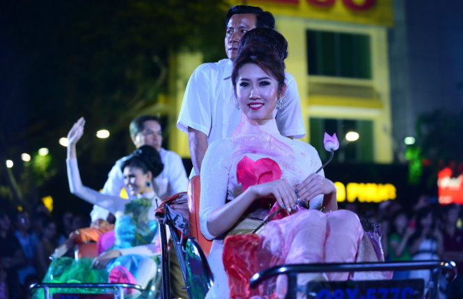 Người mẫu mặc áo dài di chuyển trên xích lô ở phố đi bộ Nguyễn Huệ.