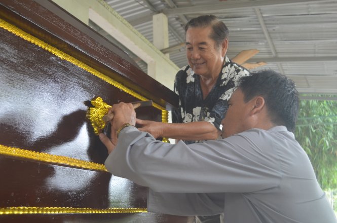 Ông Tùng (đứng) chung tay đóng hòm từ thiện... - Ảnh: M.Tâm