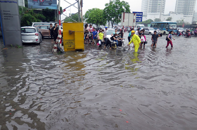 Nhân viên thoát nước óc mặt tại các điểm ngập nặng nhưng tình trạng  ngập vẫn chưa thể cải thiện - Ảnh: QUANG THẾ