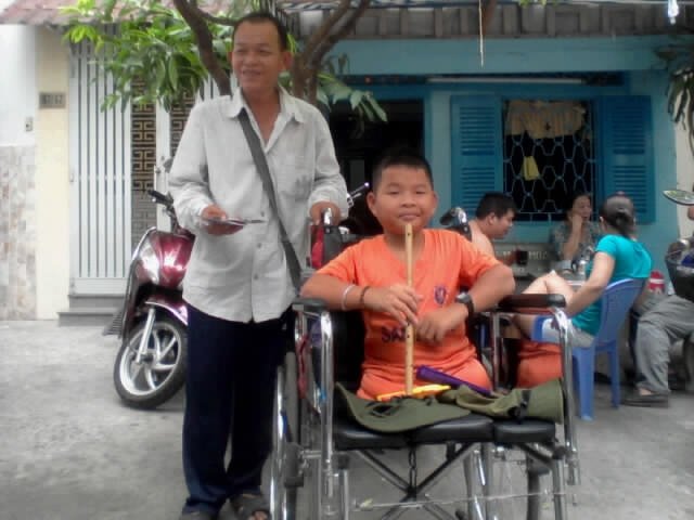 Hai cha con anh Thọ đi bán vé số - Ảnh: N.Đ.