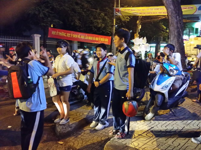 Học sinh chờ phụ huynh đón sau buổi học thêm ban đêm ở Q.5 (TP.HCM)  - Ảnh: Như Hùng