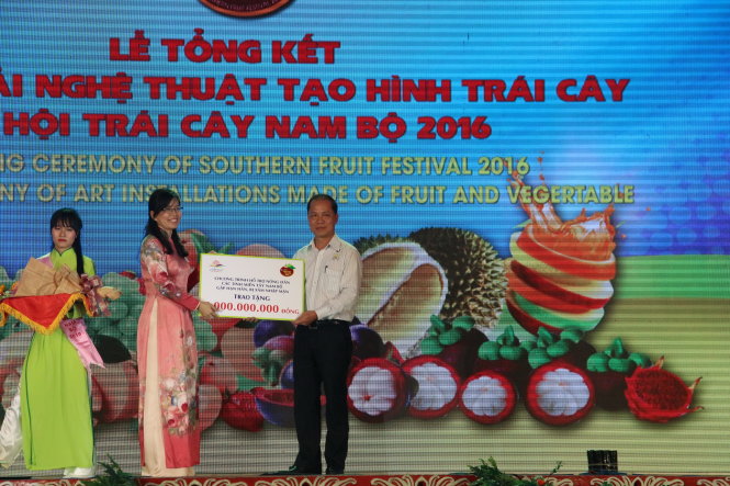 Bà Nguyễn Thị Ánh Hoa, phó giám đốc Sở Du lịch TP.HCM, trao tượng trưng số tiền 1 tỉ đồng ủng hộ “Nước cho vùng hạn, mặn” đến ông Lê Xuân Trung, phó tổng biên tập báo Tuổi Trẻ - Ảnh: MINH PHƯỢNG