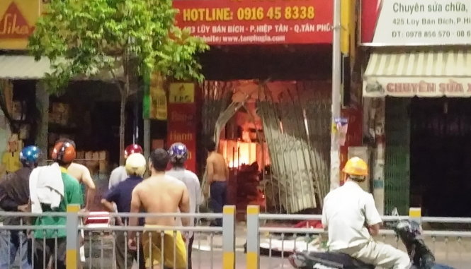 Ngọn lửa bùng lên từ cửa hàng - Ảnh: Lê Phương Đại