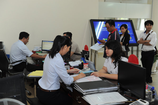 UBND Q.8 (TP.HCM) đẩy mạnh cải cách hành chính theo hướng phục vụ và tạo sự gần gũi thân thiện để người dân dễ dàng thực hiện các thủ tục giấy tờ hành chính. Trong ảnh: người dân làm thủ tục hồ sơ nhà đất tại UBND Q.8 - Ảnh: TỰ TRUNG