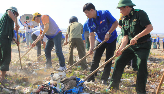 Các đại biểu, ĐVTN địa phương tham gia thu dọn rác tại bãi biển thị xã Sầm Sơn sau lễ phát động chiến dịch “Hãy làm sạch biển” sáng 19-6 - Ảnh: HÀ ĐỒNG