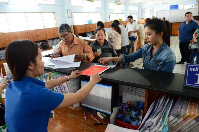 Nhân viên Văn phòng đăng ký đất đai chi nhánh Q. Gò Vấp trả hồ sơ đăng ký cho dân - Ảnh: Quang Định