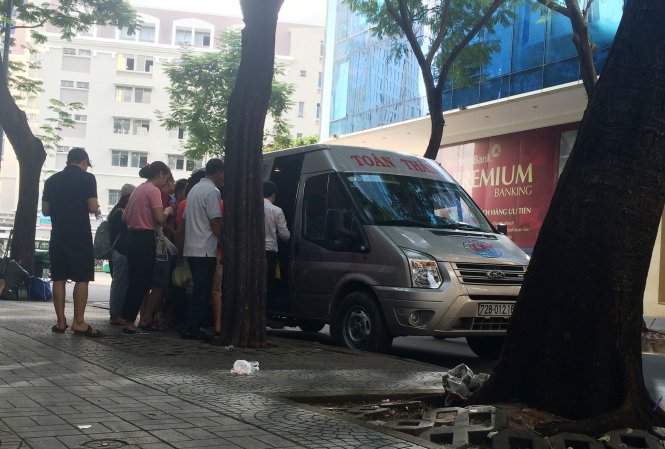 Hành khách chen nhau lên một xe Toàn Thắng đậu tại giao lộ Nam Kỳ Khời Nghĩa - Nguyễn Thái Bình - Ảnh: Lê Phan