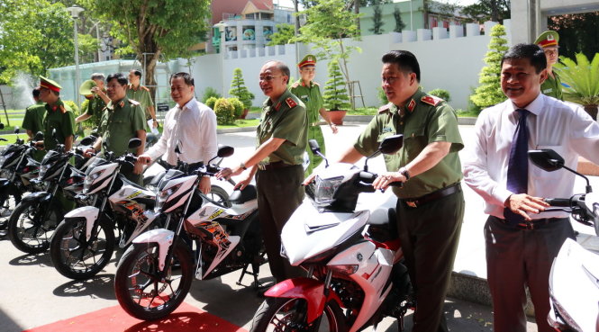 (Từ phải qua trái) Ông Huỳnh Cách Mạng - Phó Chủ tịch UBND TP, Trung tướng Bùi Văn Thành - Thứ trưởng Bộ Công an, Trung tướng Lê Đông Phong - Bí thư Đảng ủy, Giám đốc CA TP.HCM bên cạnh xe môtô bàn giao cho CA TP.HCM.