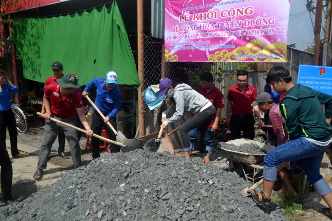 Các chiến sĩ Kỳ nghỉ hồng tất bật xúc sạn để chuẩn bị bêtông hóa một tuyến hẻm tại thị trấn Tân Túc (Bình Chánh) - Ảnh: QUANG PHƯƠNG