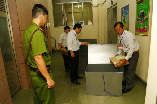 Quá trình vận chuyển đề thi luôn có sự giám sát của công an. Trong ảnh: các cán bộ chuyển đề thi đến các điểm thi của cụm thi tại một trường ĐH ở TP.HCM - Ảnh: NHƯ HÙNG