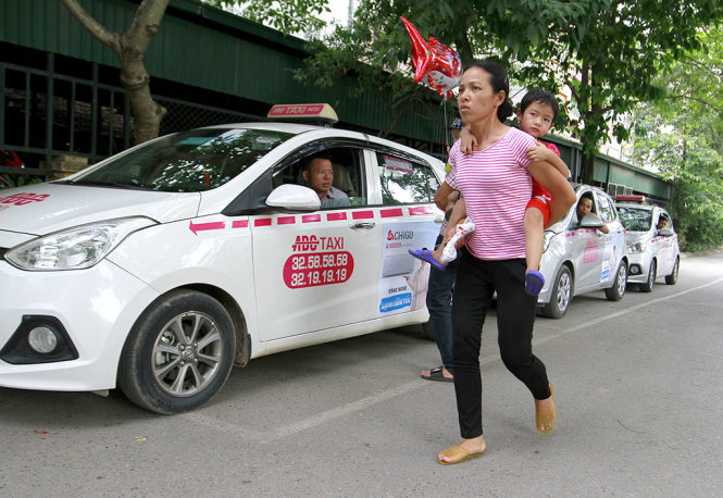 Xe taxi Hãng ABC xếp hàng dài trong khuôn viên Bệnh viện Nhi T.Ư, nếu khách không muốn đi xe hãng này thì phải đi bộ ra ngoài đường để đón xe khác - Ảnh: NAM TRẦN