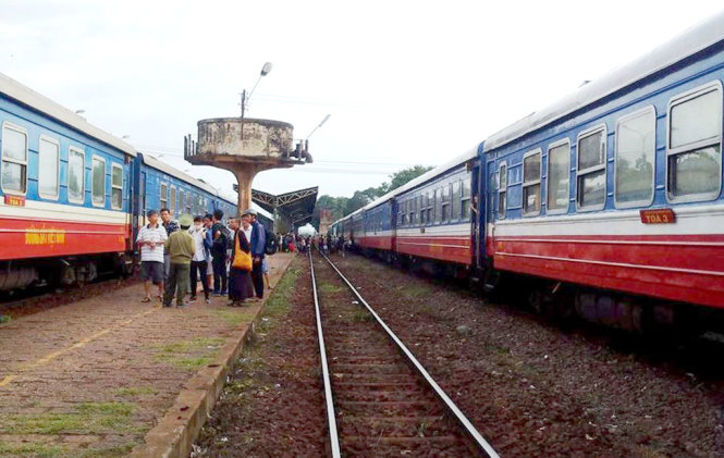 Đoàn tàu (bên trái) bị cháy bồn dầu đầu máy được kéo về ga Bình Thuận - Ảnh: QUANG HƯNG