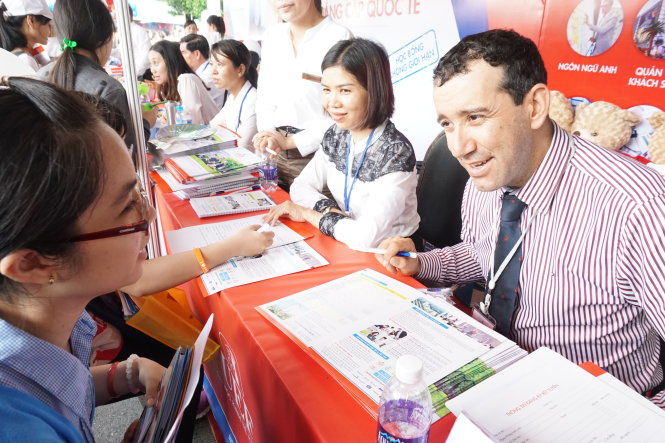 Mỗi trường có cách riêng để thu hút học sinh, phụ huynh đến gian hàng của mình. Trường ĐH Kinh tế - tài chính TP.HCM nổi bật nhờ vào việc có 2, 3 thầy cô là “ông Tây, bà Tây” - Ảnh: MỸ DUNG