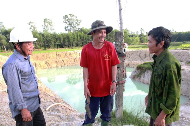 Ba Quý (trái) trò chuyện với người dân ở ngã ba Ba Quý, cạnh cái hồ ông bỏ tiền đào lấy nước tưới cho dân - Ảnh: TRẦN MAI