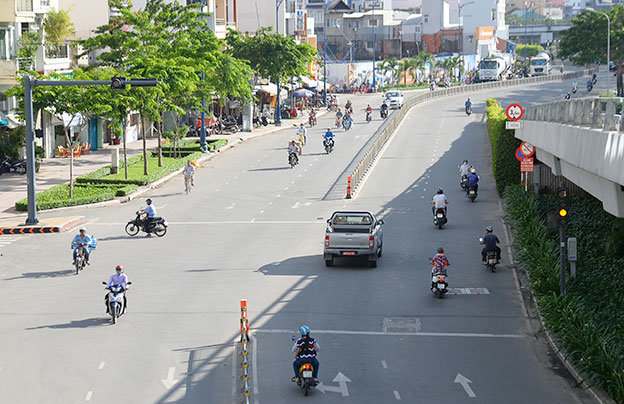 Ôtô và xe máy vượt đèn vàng tại giao lộ đường Bến Vân Đồn và đường Vĩnh Khánh (Q.4, TP.HCM) - Ảnh: HỮU KHOA