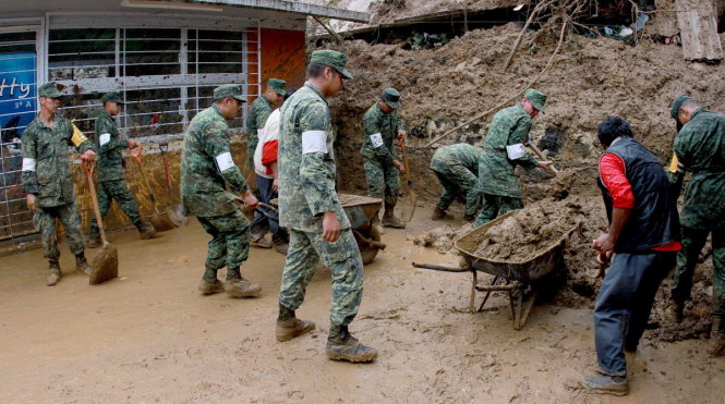 Quân đội Mexico đào bới bùn đất tìm nạn nhân trong những ngôi nhà bị vùi lấp - Ảnh: AFP