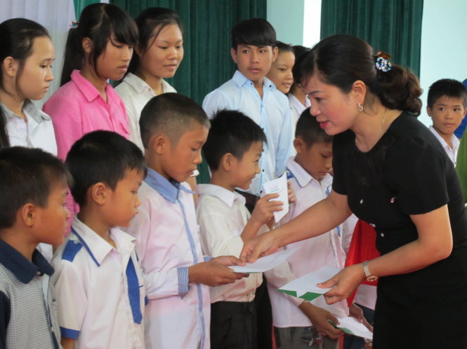 Các em học sinh nhận học bổng và quà từ chương trình - Ảnh: HỒ VĂN