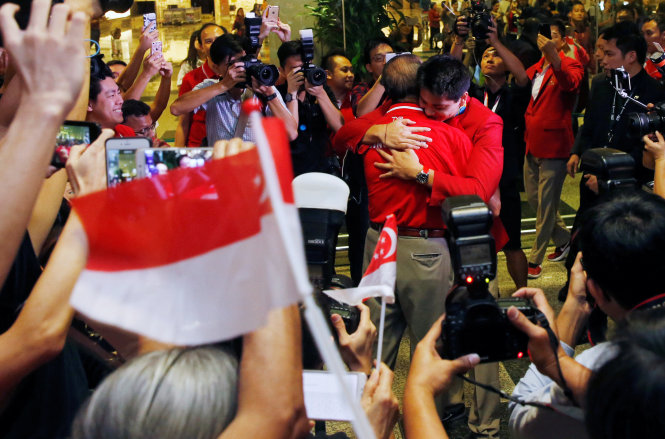 Schooling ôm cha của anh khi đặt chân xuống sân bay Changi. Ảnh: REUTERS