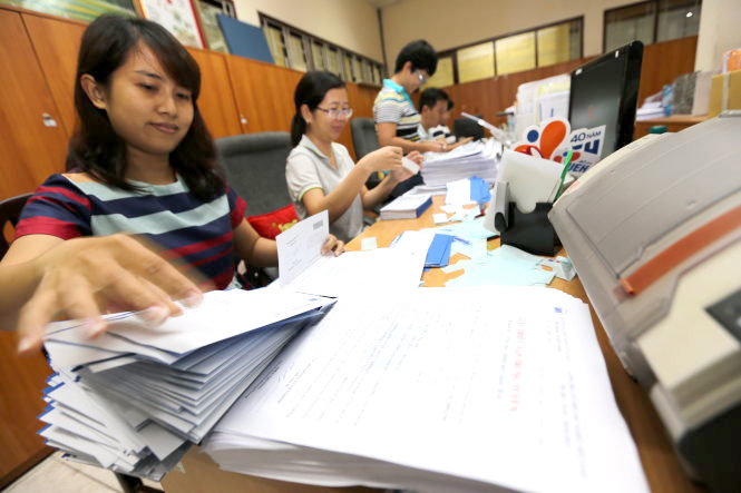 Cán bộ phòng đào tạo Trường ĐH Kinh tế TP.HCM ráo riết chuẩn bị giấy triệu tập trúng tuyển của trường gửi cho thí sinh để làm thủ tục nhập học (ảnh chụp chiều 14-8) - Ảnh: NHƯ HÙNG