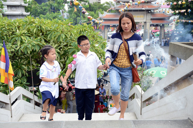 Những em nhỏ được cha mẹ đưa đi chùa trong những ngày này để nhớ về nguồn cội - Ảnh: DUYÊN PHAN
