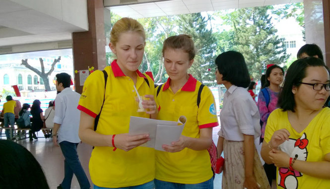 Hai bạn trẻ đến từ Belarus chăm chú đọc thuyết minh về ý nghĩa các phong tục ngày tết cổ truyền - Ảnh: Duy Linh