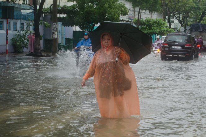 Một người dân đi bộ trên đường trong nước ngập tại Đà Nẵng chiều 12-9 - Ảnh: TẤN LỰC