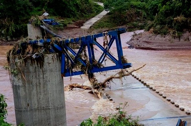 Cầu treo bị lũ cuốn trôi, chỉ còn phần trụ móng và khung – Ảnh: THÀNH BÙI