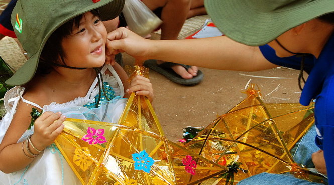 Một em nhỏ ở Đồng Tháp vui sướng khi được các anh chị sinh viên tình nguyện tặng lồng đèn trung thu - Ảnh: MAI VINH
