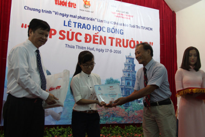 Ông Nguyễn Dung - phó chủ tịch UBND tỉnh Thừa Thiên - Huế (trái) và PGS.TS Nguyễn Thiện Tống - chủ nhiệm CLB “Tiếp sức đến trường” Thừa Thiên - Huế trao học bổng cho tân sinh viên nghèo vượt khó - Ảnh: MINH AN