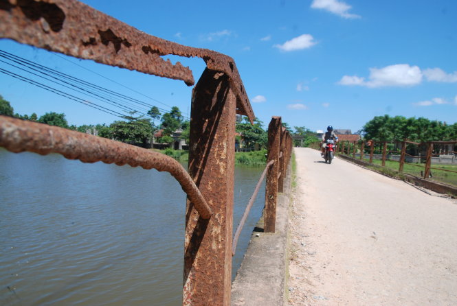 Hệ thống lan can cầu Câu Nhi đã hoen rỉ và đứt gãy nhiều đoạn vô cùng nguy hiểm cho người đi qua cầu – Ảnh: QUỐC NAM