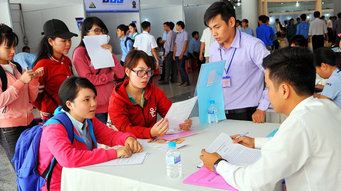 Lao động tìm hiểu thông tin và nộp hồ sơ tại một bàn đăng ký của doanh nghiệp tại ngày hội việc làm - Ảnh: A Lộc