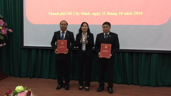 Bà Ung Thị Xuân Hương, giữa, Chánh án TAND TP.HCM trao quyết định bổ nhiệm cho 2 thẩm phán - Ảnh: HOÀNG ĐIỆP