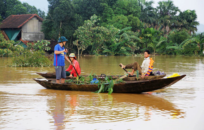 Nước lũ dâng cao ngập gần nóc nhà ở rốn lũ Phương Mỹ, huyện Hương Khê (Hà Tĩnh) nên người dân phải di chuyển bằng thuyền vào chiều 16-10 - Ảnh: DOÃN HÒA