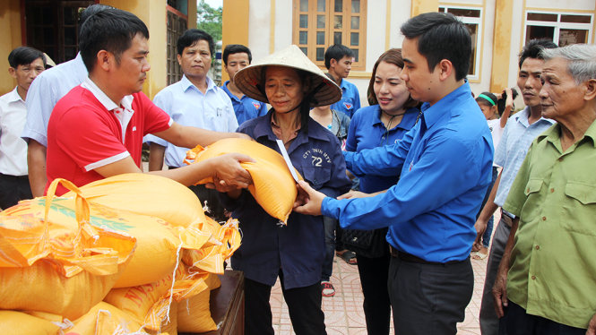 Đại diện báo Tuổi trẻ và tỉnh đoàn Hà Tĩnh trao 200 phần quà, mỗi phần gồm 20kg gạo và 500.000 đồng của bạn đọc báo Tuổi trẻ cho người dân xã Hương Giang, huyện Hương Khê chiều 18-10 - Ảnh: DOÃN HÒA