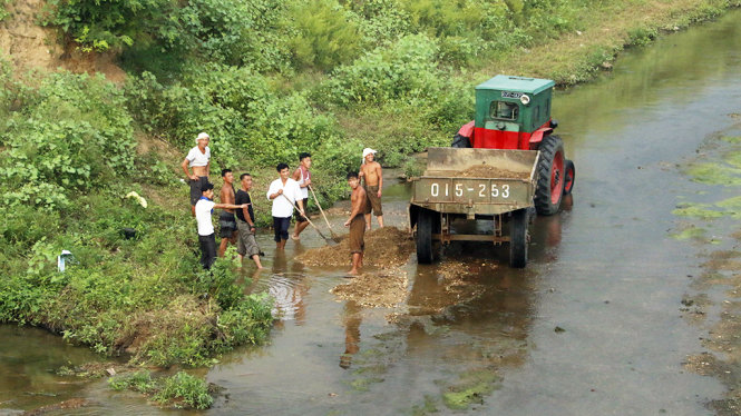 Xúc cát dưới một dòng suối ở tỉnh Bình An Nam -  Ảnh: THÁI LỘC